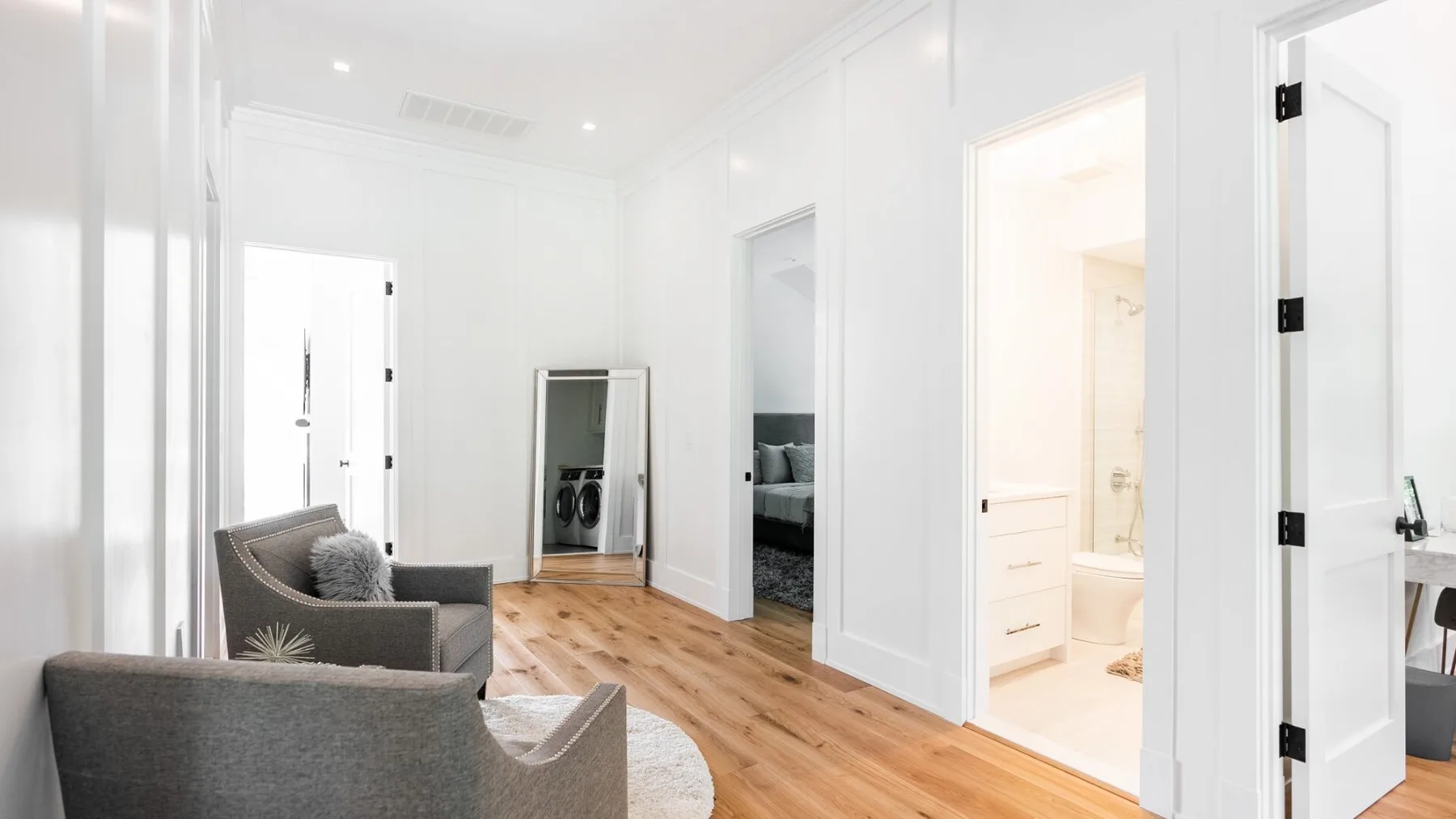 A bright living room with seating and light wood flooring.