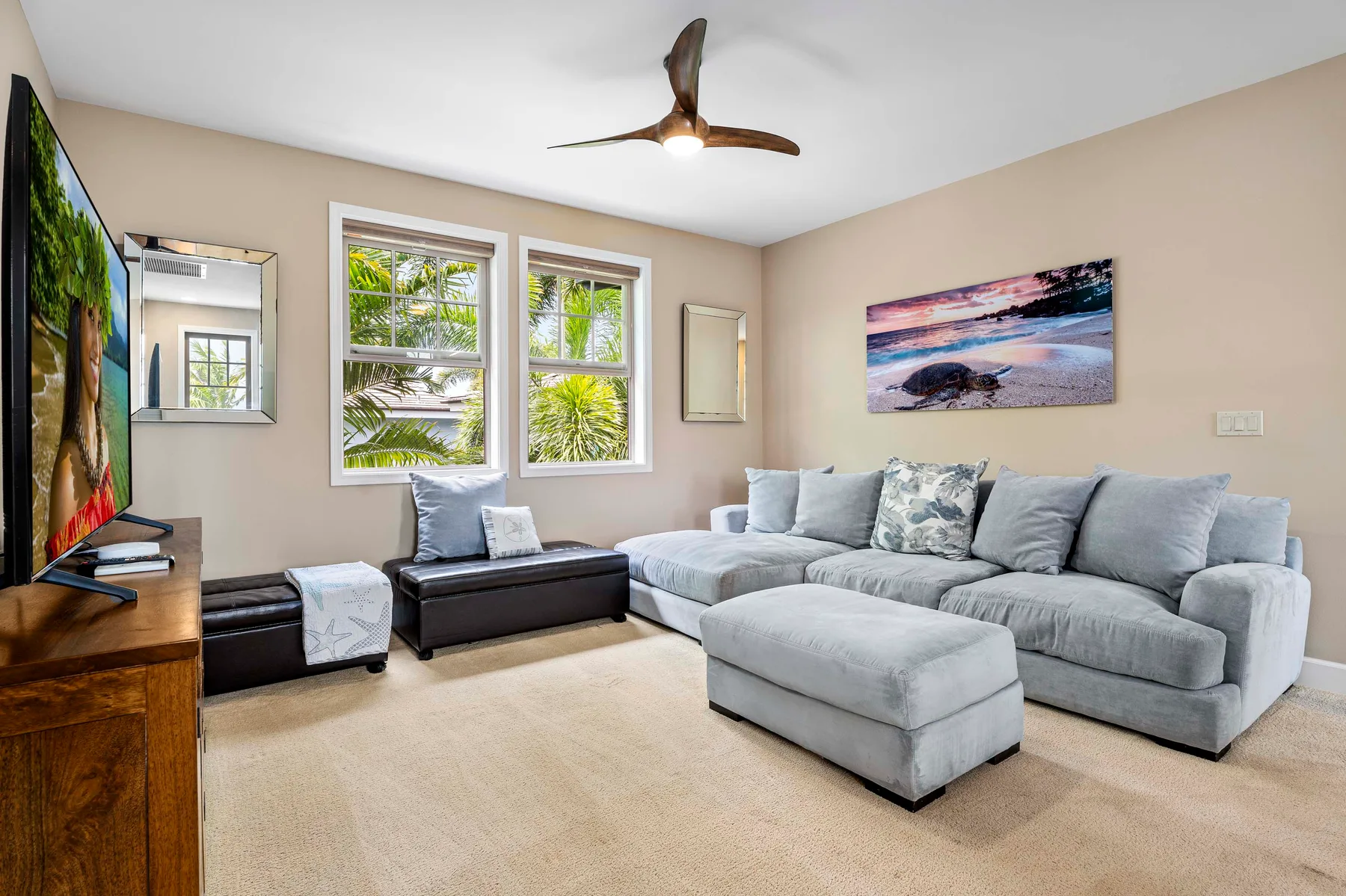 A living room with a gray sectional and television.