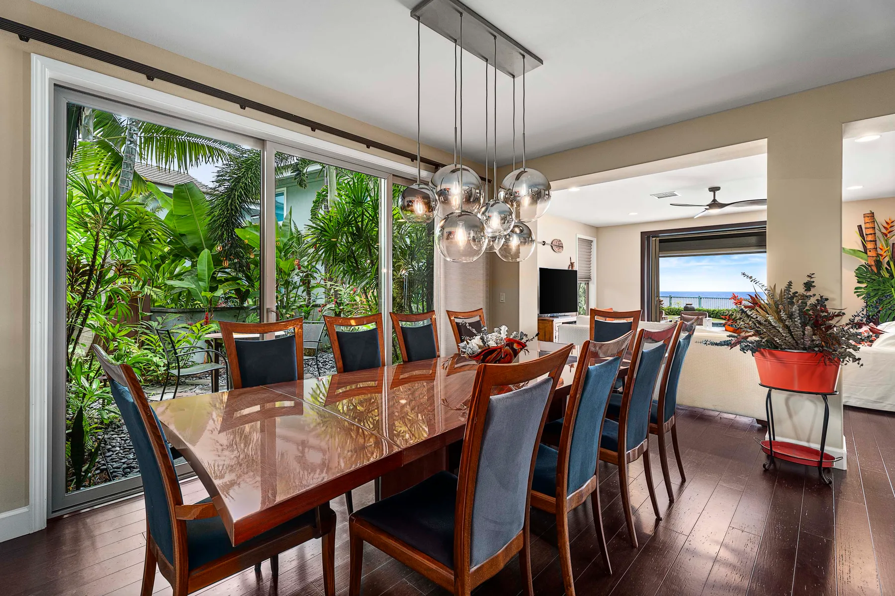 A dining area with a long table and chairs beside large windows.