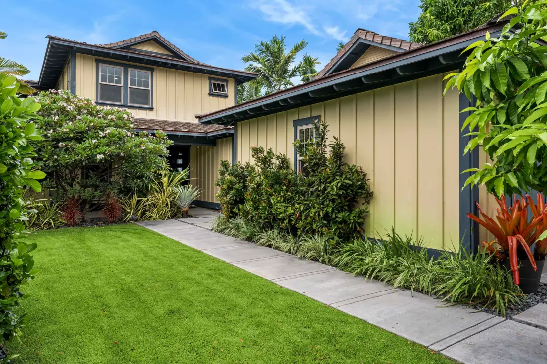 A landscaped garden path runs beside a cream-colored house.