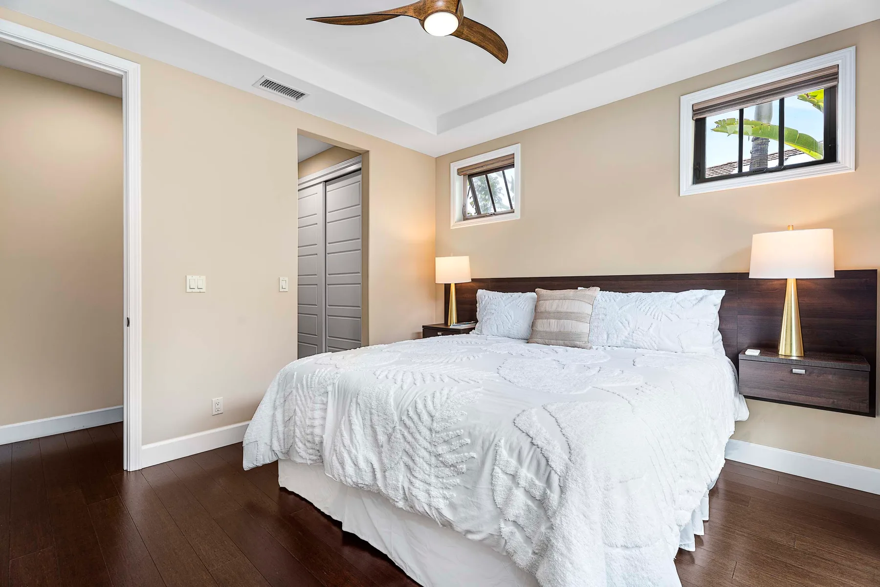 A bedroom with a neatly made bed and matching bedside lamps.