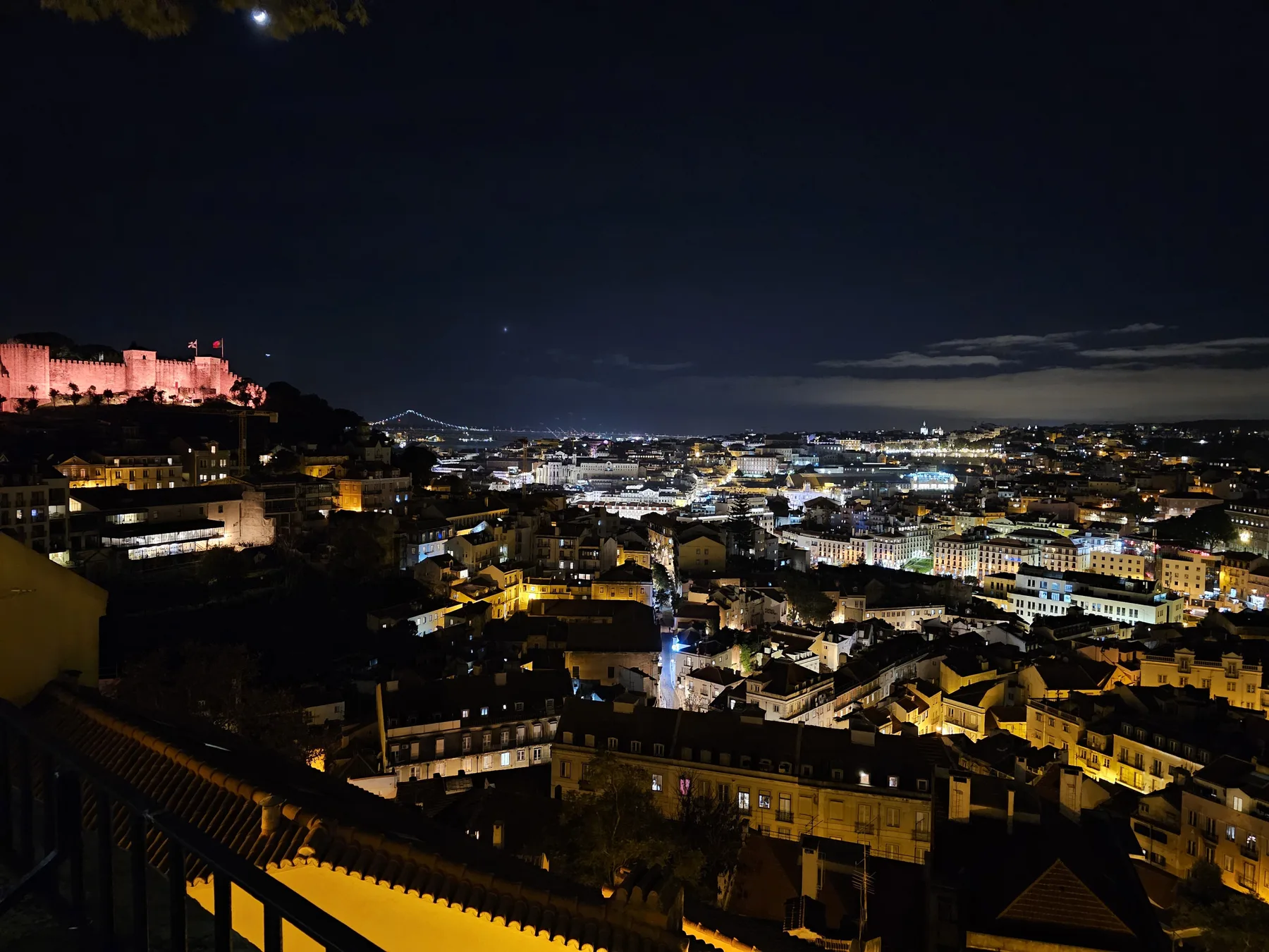 Paisaje urbano nocturno con edificios históricos iluminados y un horizonte lejano.