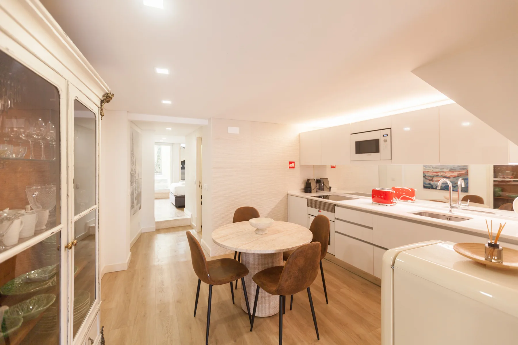 Una cocina luminosa con comedor, mesa redonda y armarios empotrados.