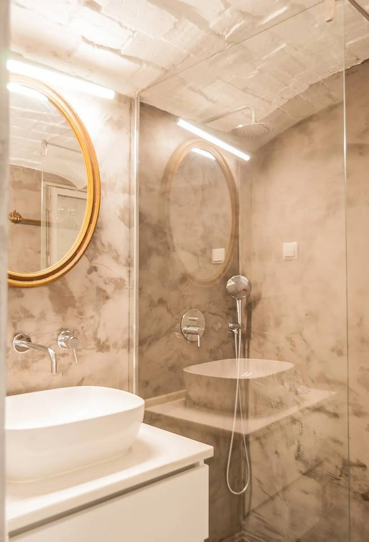 Un baño con lavabo sobre encimera y ducha de vidrio.
