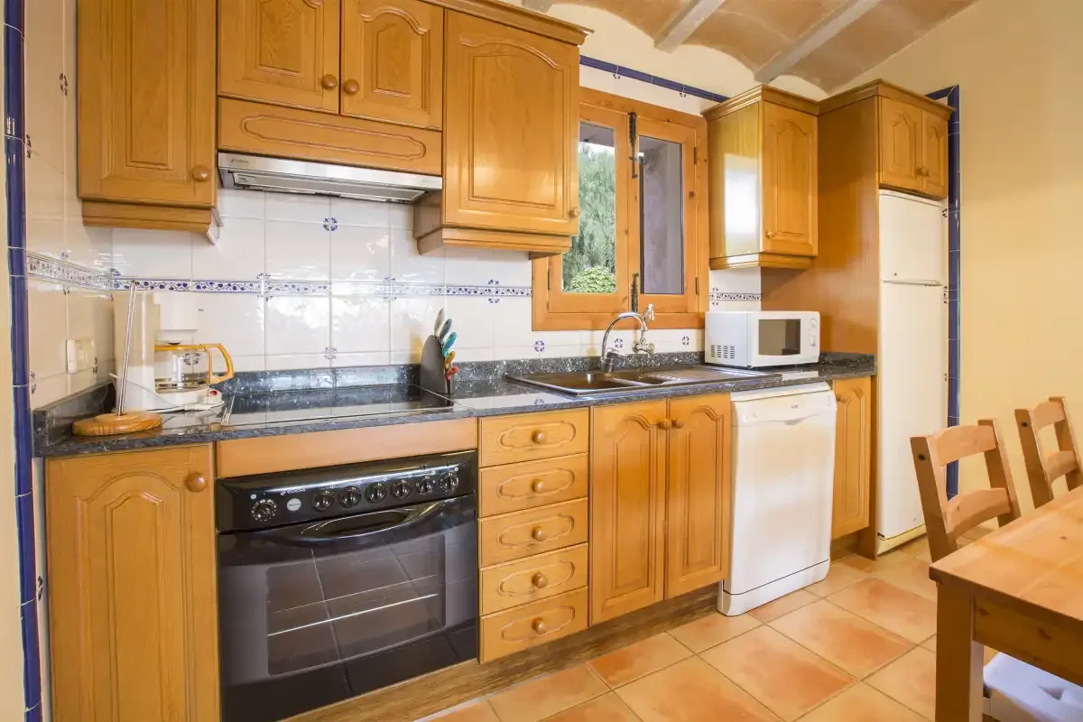 A kitchen with wooden cabinets, a countertop, and a dining table.