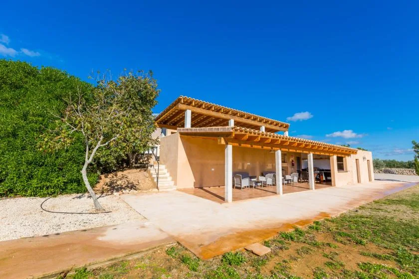 A single-story house with a covered patio and outdoor seating.