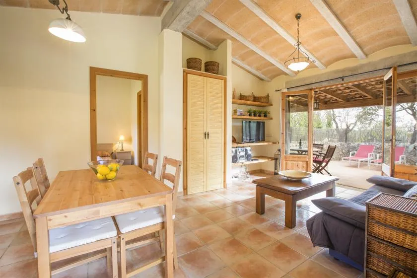 A bright open-plan living and dining room with a wooden table and seating.