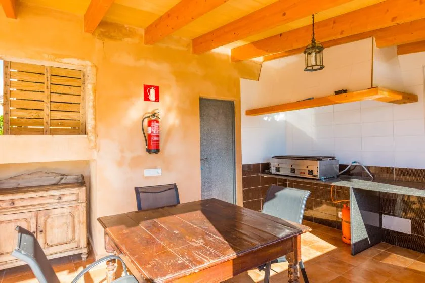 A rustic kitchen and dining area with a wooden table and countertop.