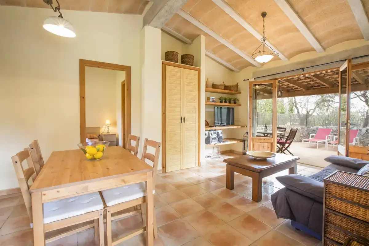 A dining and living area opens onto a glass-enclosed patio.