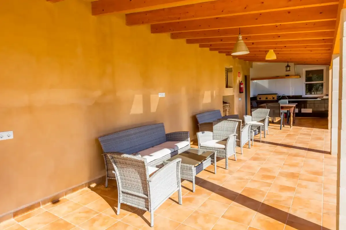 A covered terrace with seating and a kitchen area at the far end.