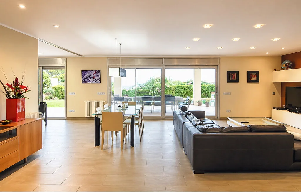 A spacious living and dining area opens onto a patio through large glass doors.