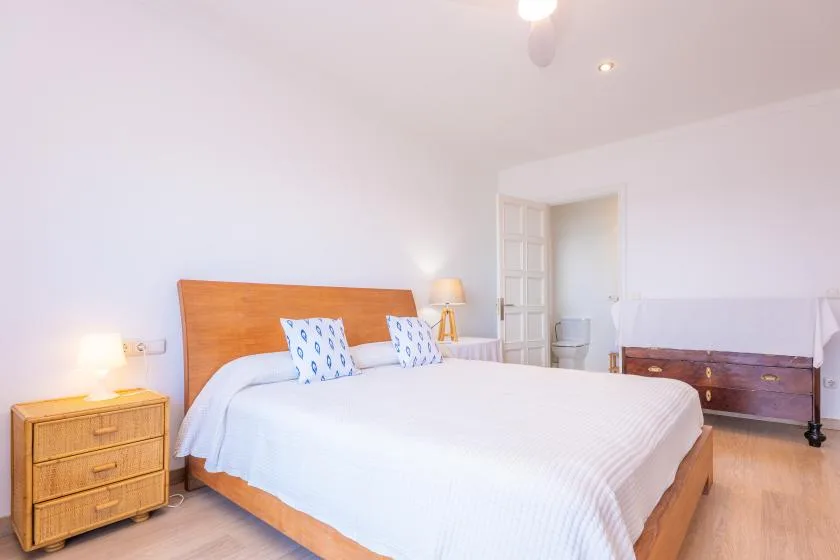 A bright bedroom with a large bed and bedside tables.