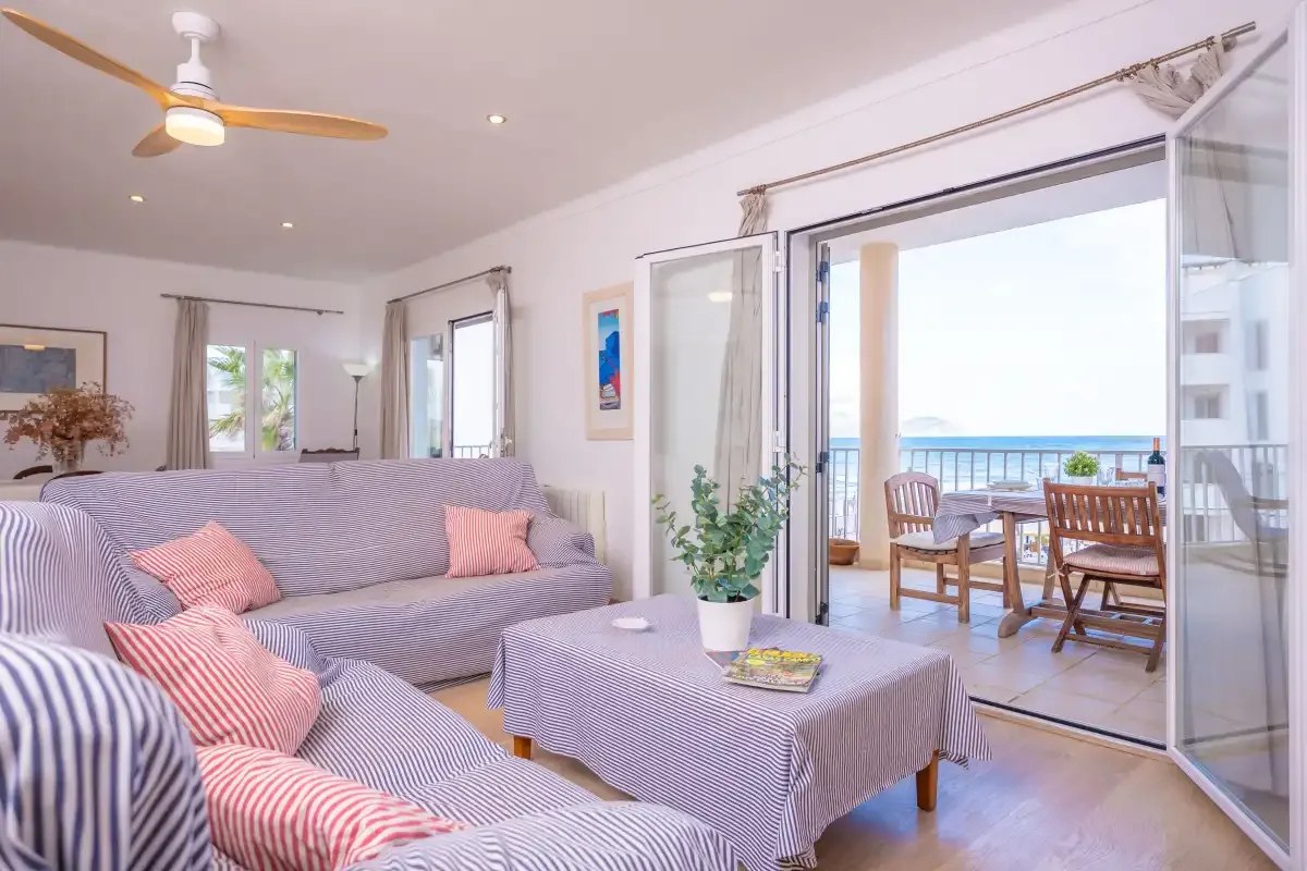 A living room with seating and an open sliding glass door to a balcony.