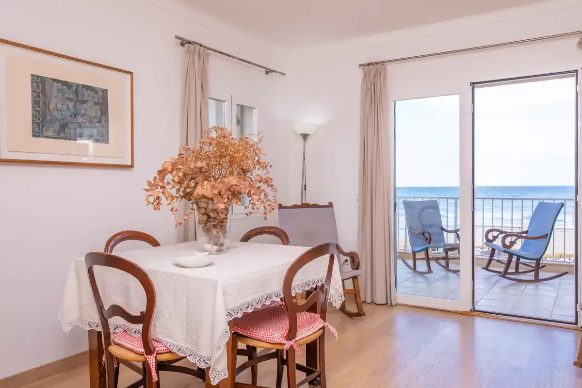 A dining area with a table set beside glass doors opening onto a balcony.