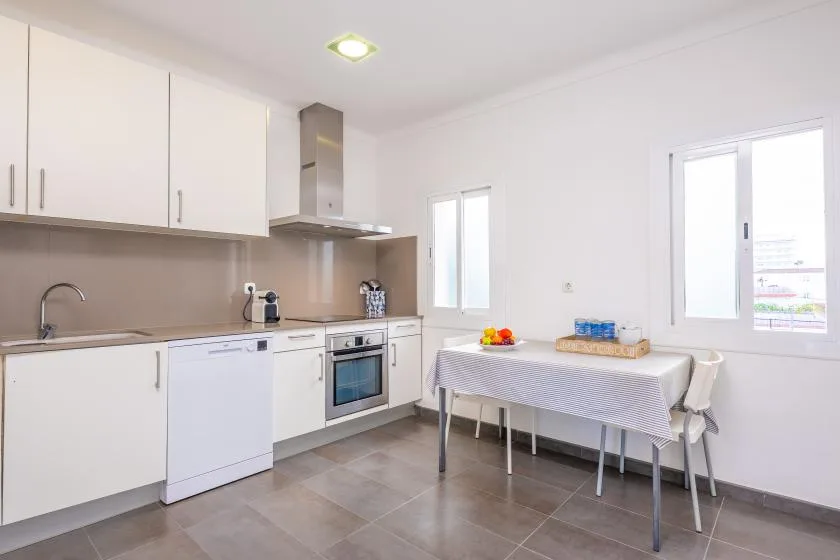 A bright kitchen with a dining table and windows.