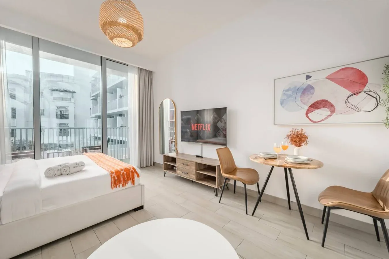 Un estudio con una cama, asientos y una pequeña mesa de comedor.