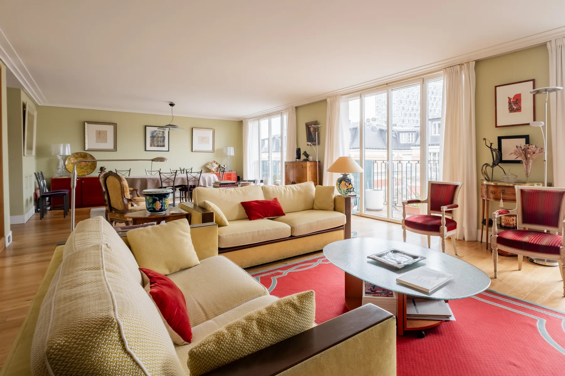 A bright living room with seating around a coffee table and large windows.