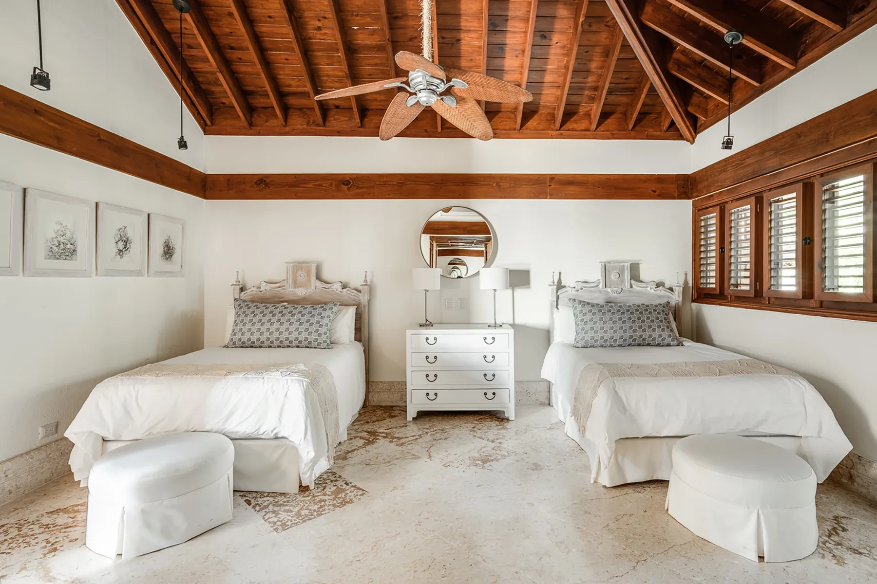 Un dormitorio con dos camas, una cómoda y vigas de madera expuestas en el techo.