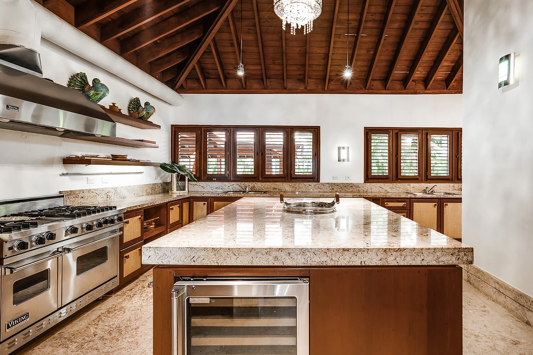 Una cocina amplia con una isla grande, una estufa y vigas de madera en el techo.