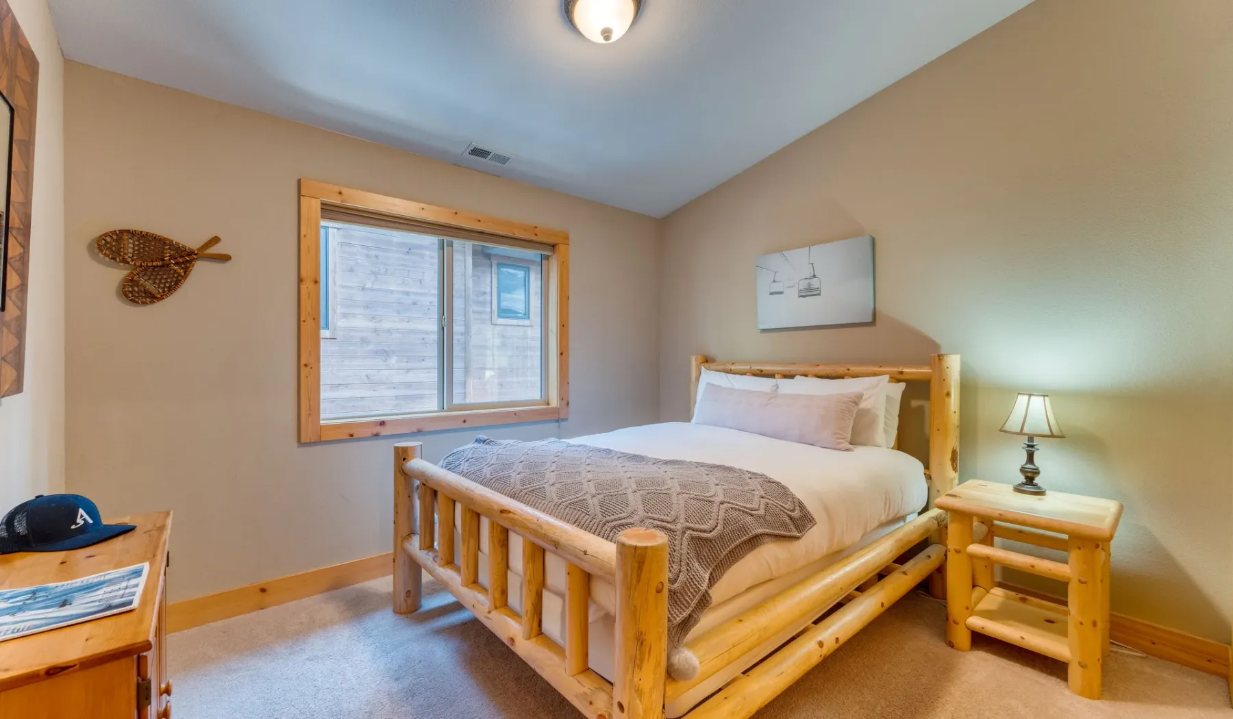 A bedroom with a wooden bed, patterned bedding, and a window.