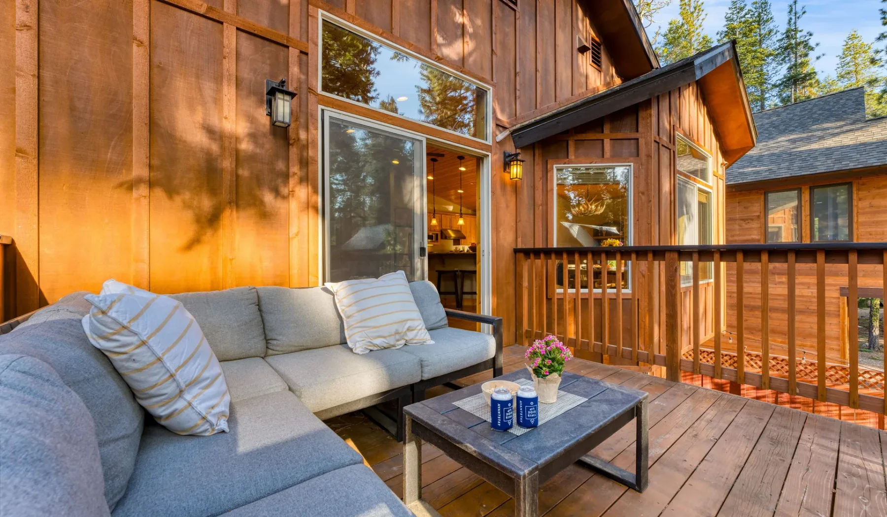 A wooden deck with outdoor seating and a small table beside the house.