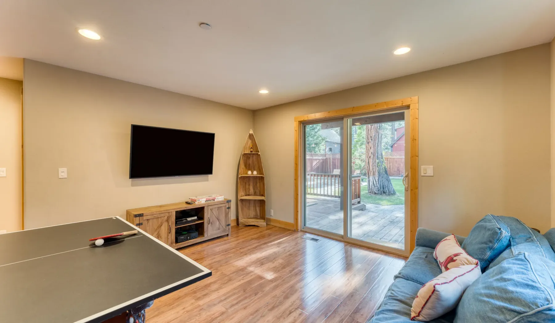 A living room with a television, seating, and glass doors opening onto a patio.