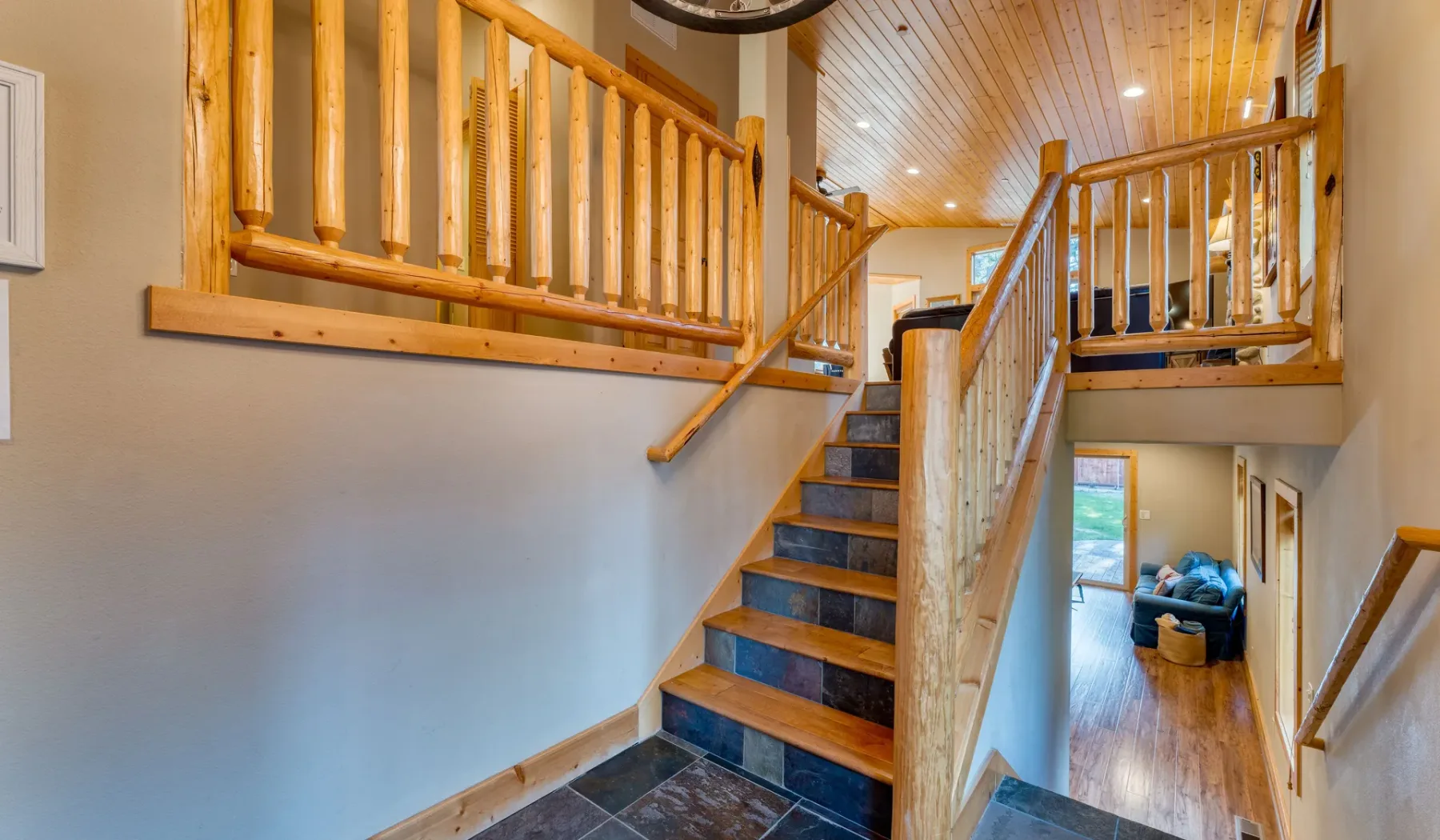 A wooden staircase with railings leads to an upper landing.