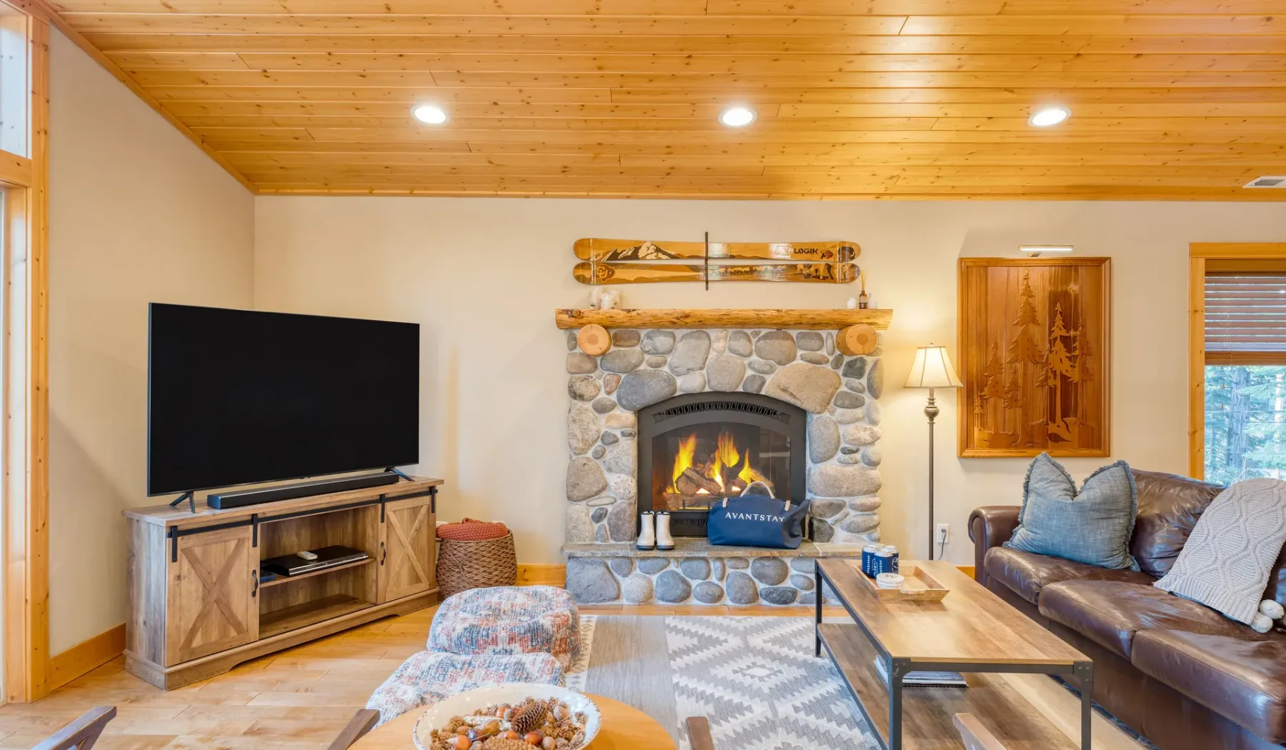 A living room with a stone fireplace, television, and seating.