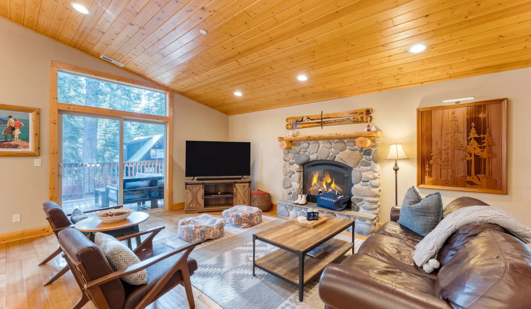 A living room with a stone fireplace and seating around a coffee table.