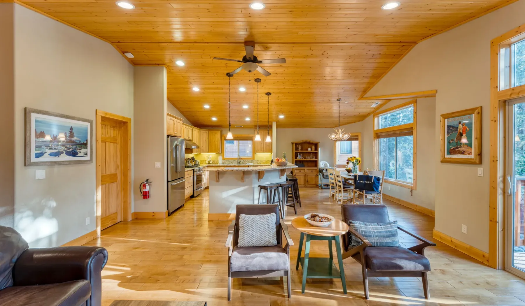 An open-plan living and kitchen area has a dining counter and large windows.
