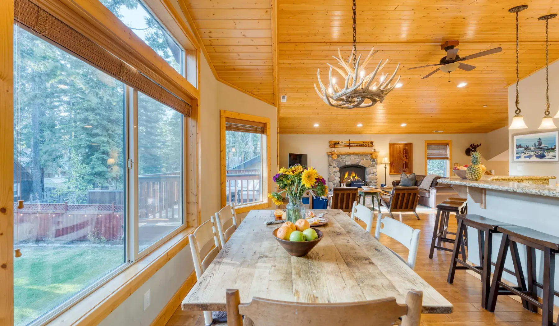 A wood-paneled dining area with a long table beside large windows.