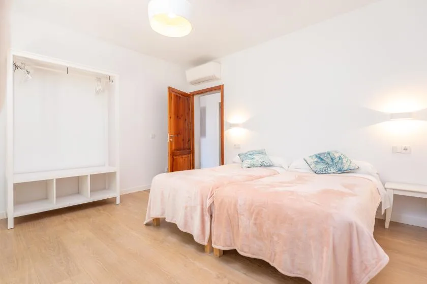Un dormitorio luminoso con una cama doble y estanterías empotradas.