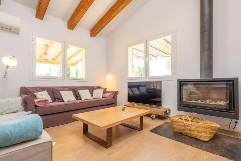 Una sala de estar luminosa con asientos, una mesa de centro y una chimenea.
