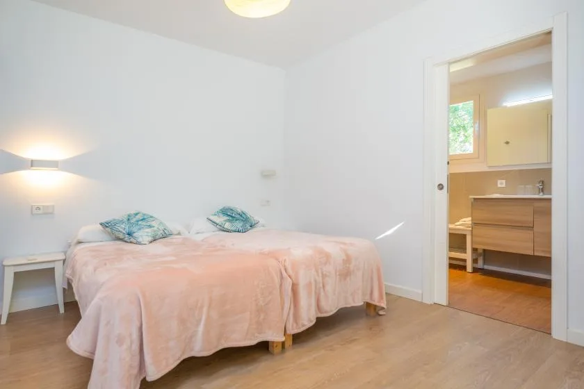 Un dormitorio con una cama y una puerta abierta hacia un baño.