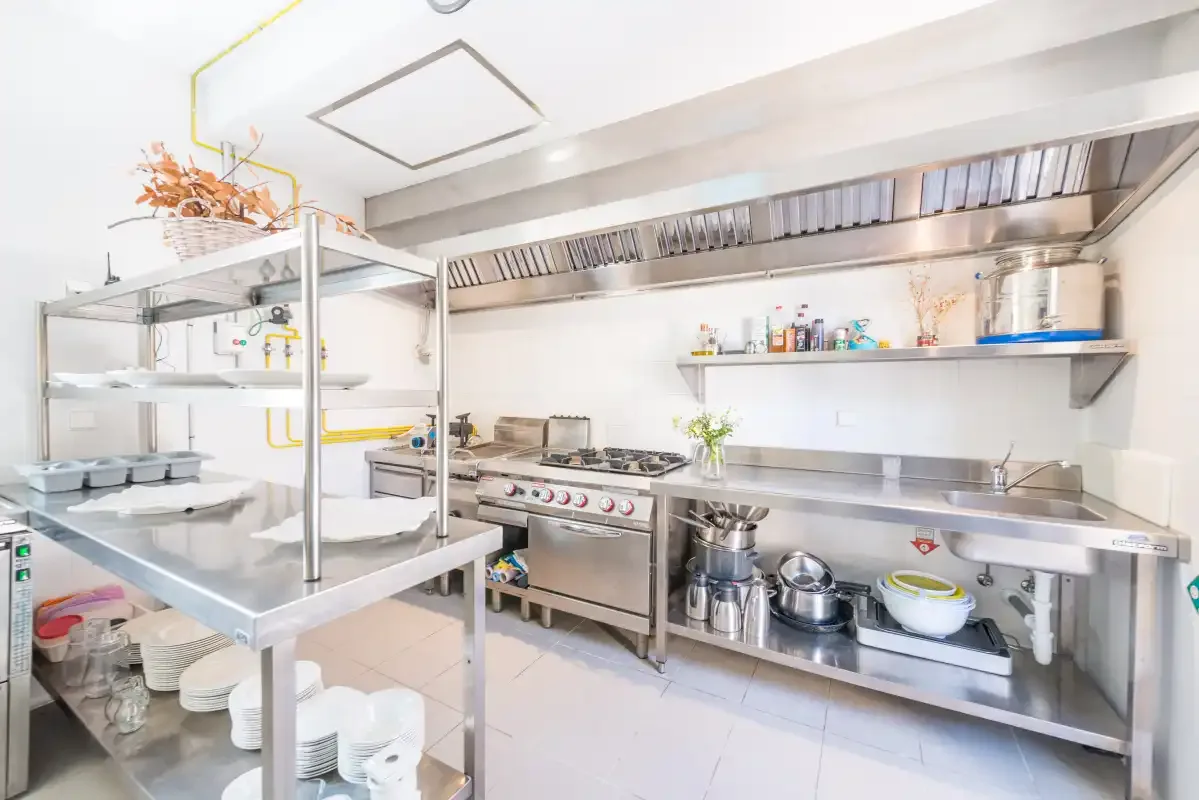 Una cocina comercial con superficies de trabajo de acero inoxidable y equipo de cocina.