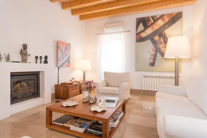 Una sala luminosa con asientos, una mesa de centro de madera y arte colorido en las paredes.