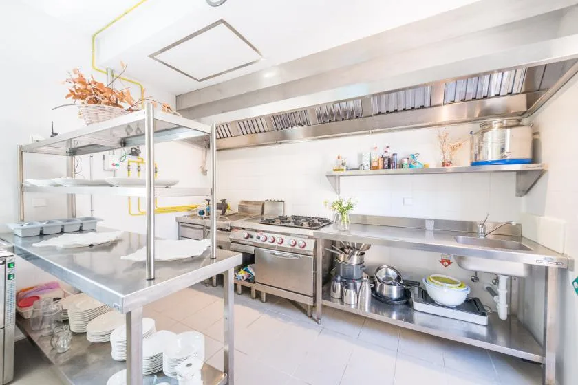 Una cocina comercial con superficies de trabajo de acero inoxidable y equipo de cocina.
