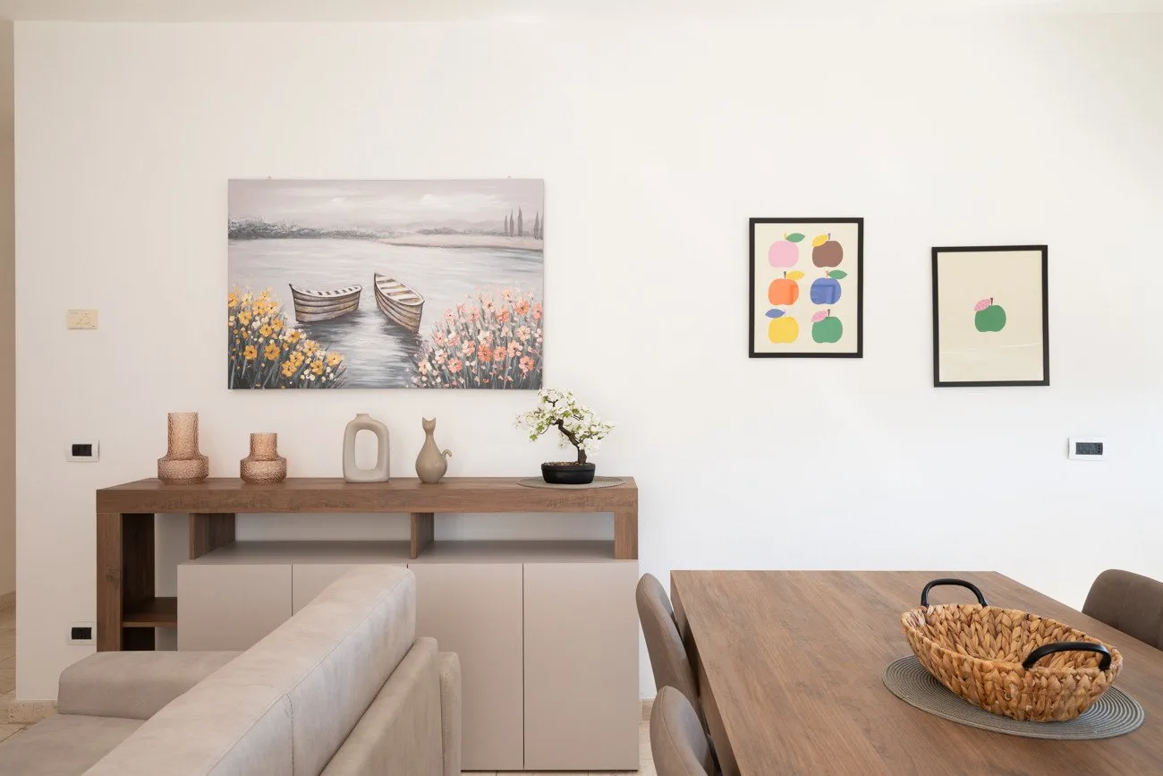 Comedor con una mesa de madera y cuadros en la pared.