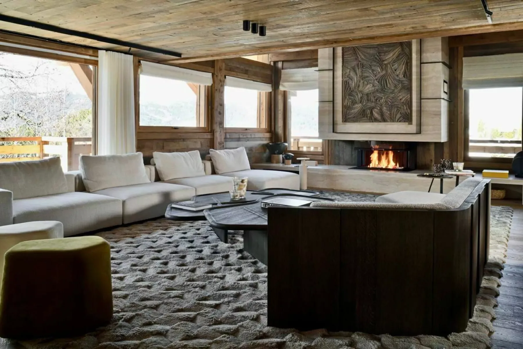 Una amplia sala de estar con asientos alrededor de una mesa baja y una chimenea.
