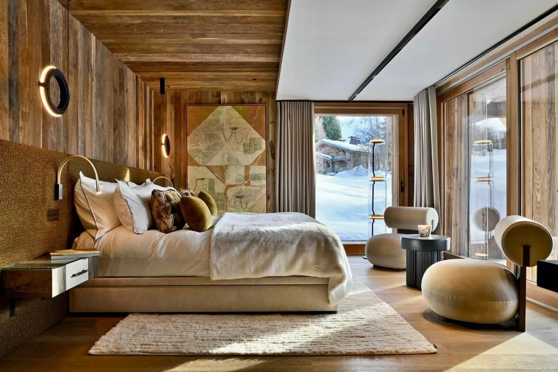 Dormitorio con cama, paredes revestidas de madera y grandes ventanales.
