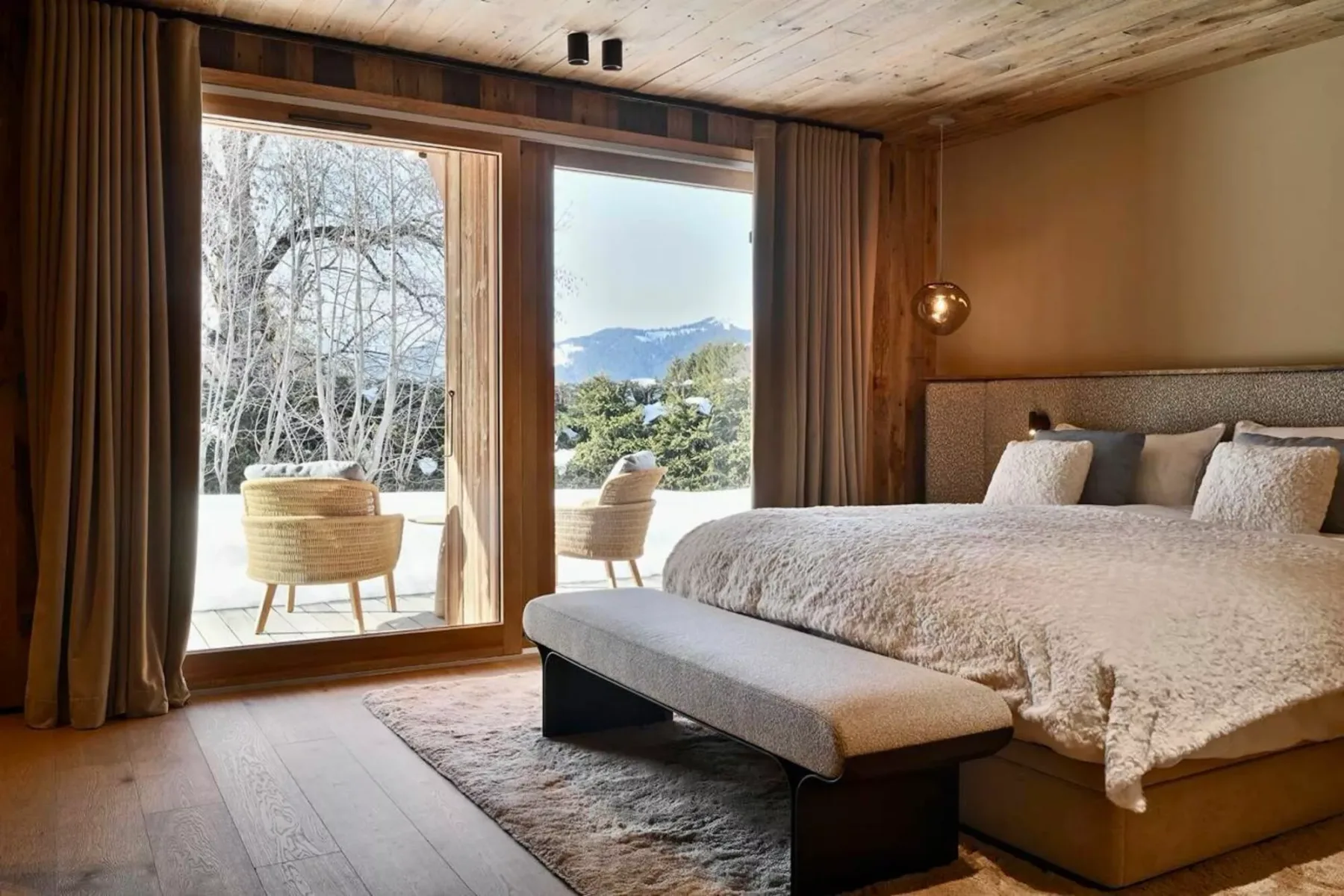 Un dormitorio con una cama grande y una ventana con vistas a un paisaje nevado.