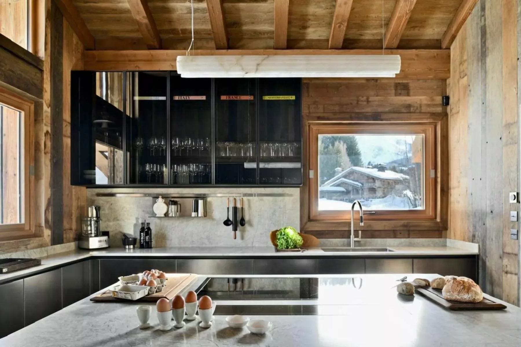 Una cocina revestida de madera con gabinetes oscuros y una amplia isla central.