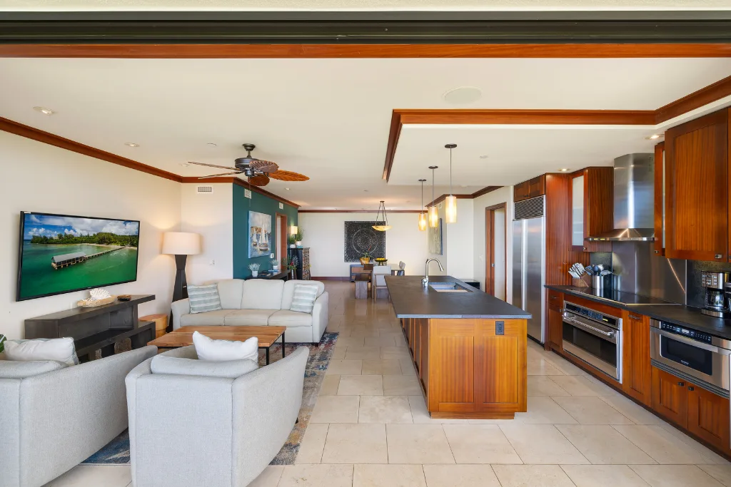 Una sala de estar y cocina de concepto abierto con asientos, una isla central y gabinetes de madera.