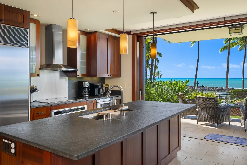 Una cocina se abre a un patio exterior con vistas al mar.
