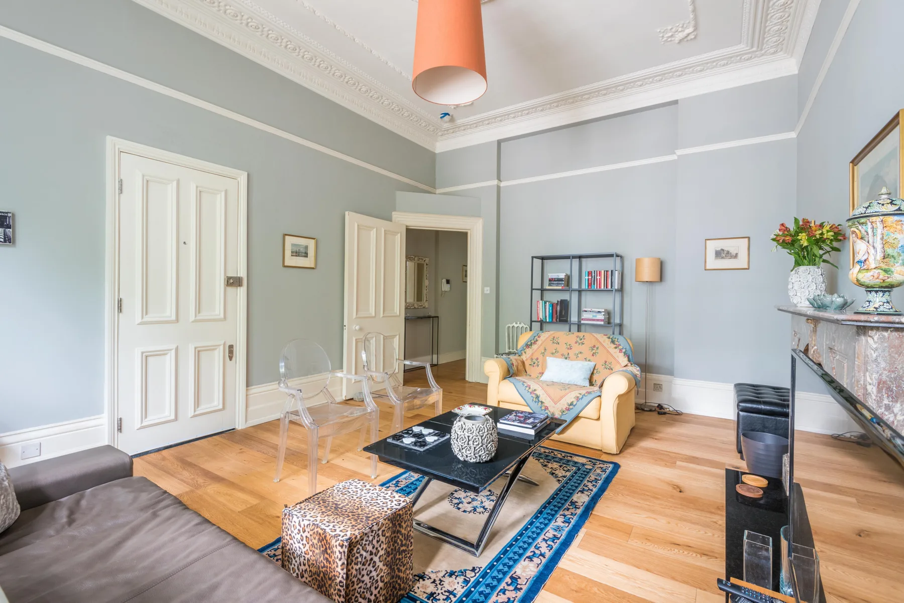 A bright living room with seating arranged around a coffee table and patterned rug.