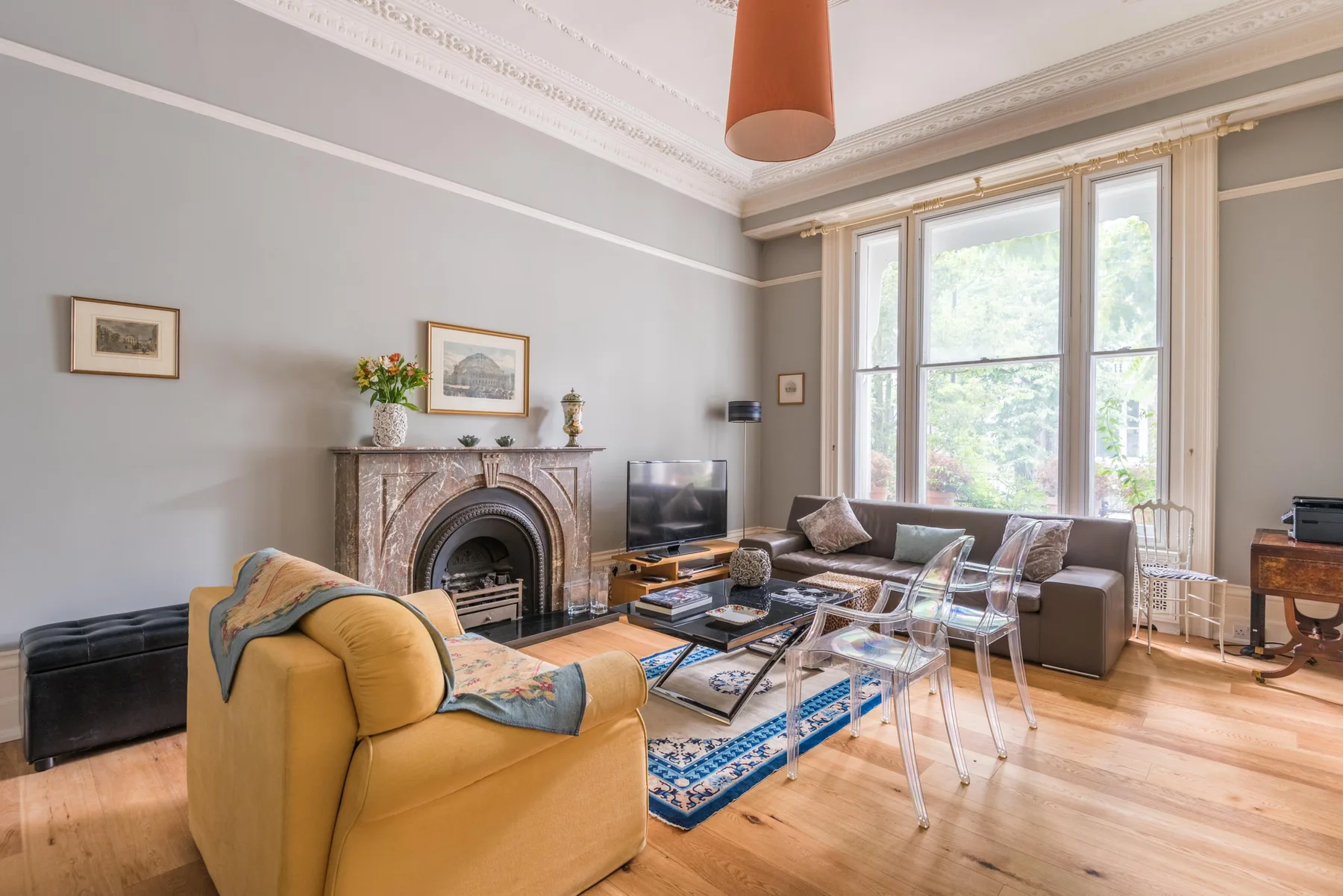 A living room with seating around a fireplace and a large rug.