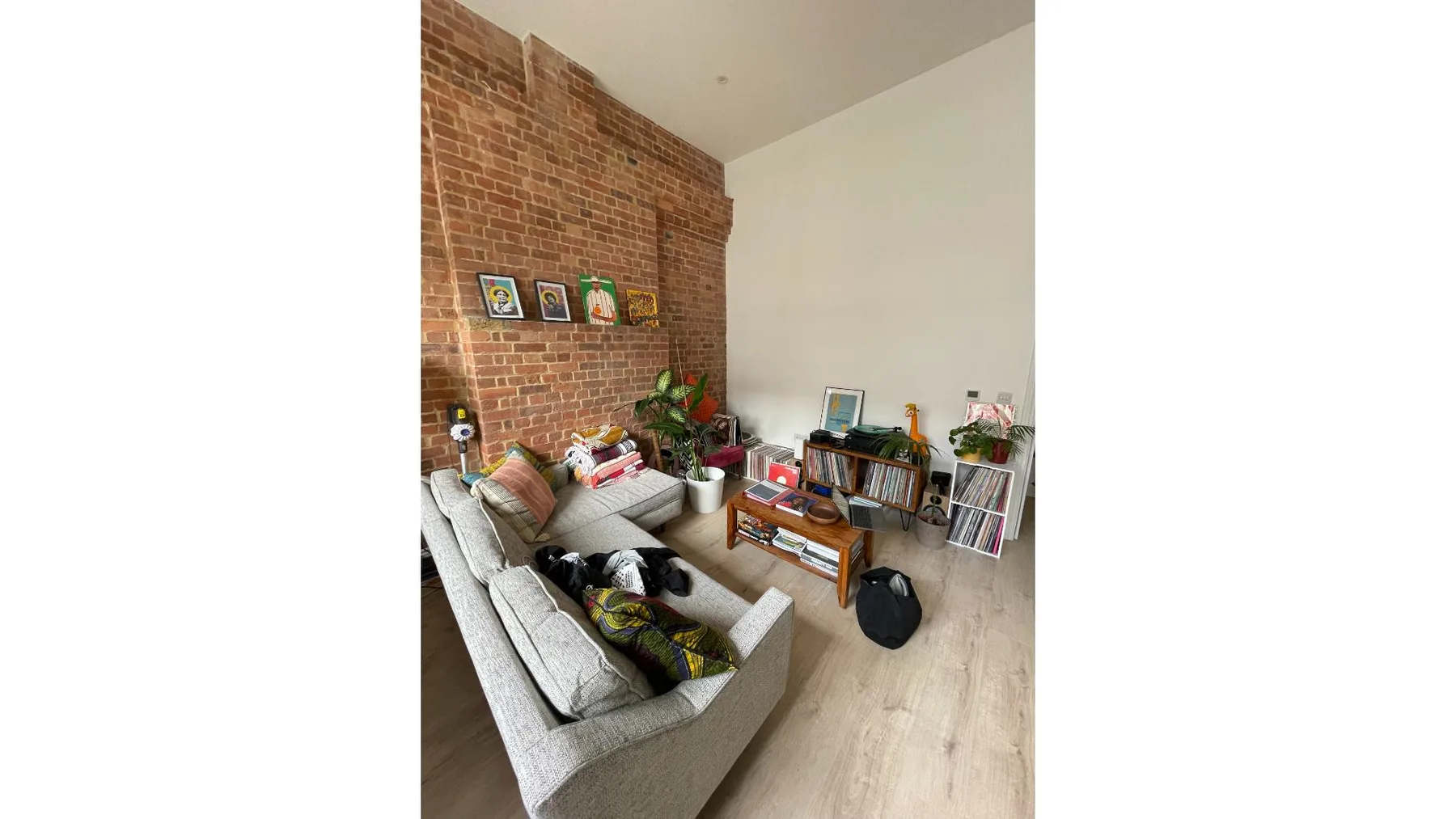 A living room with seating, a brick wall, and a low table.