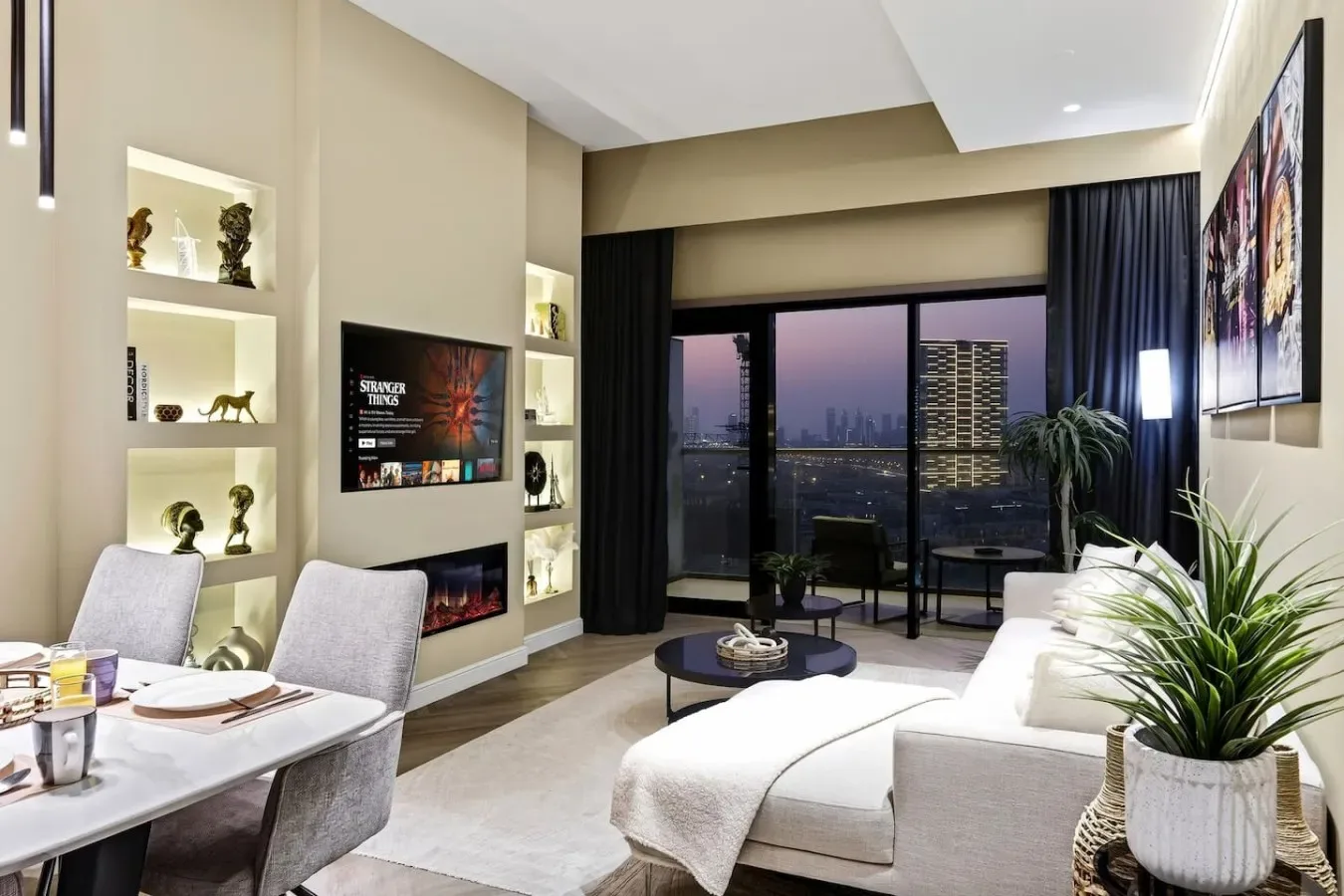 A modern living room with seating and large windows overlooking the city.