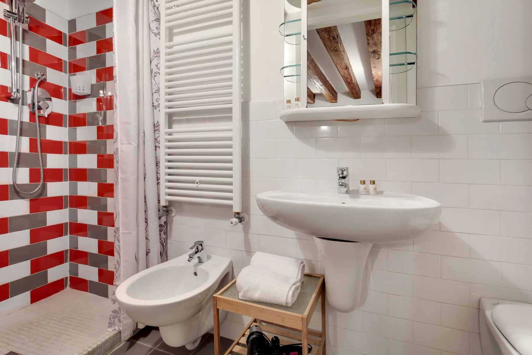 A tiled bathroom with a sink, bidet, and shower area.