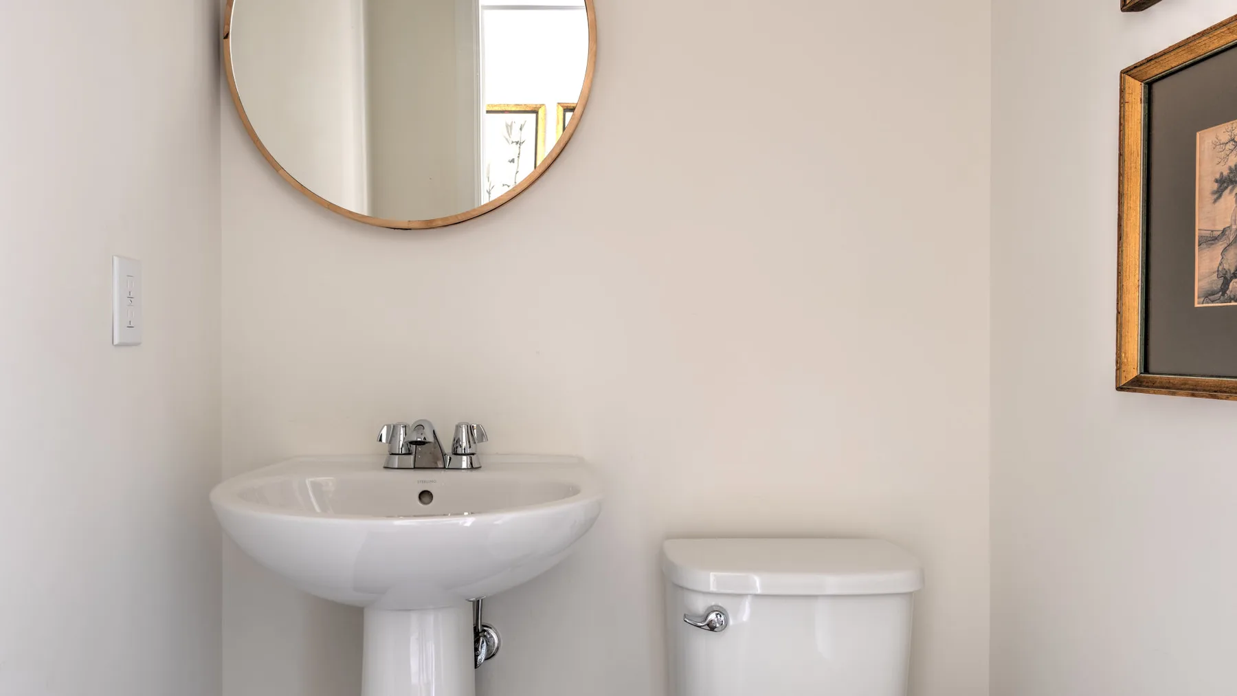 Un lavabo de baño con espejo y un inodoro.